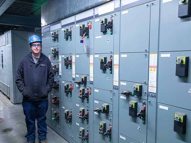 Man standing by electrical panel.