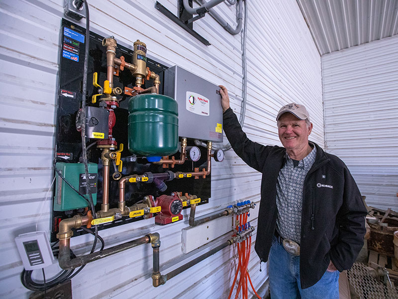 man standing next to geothermal heat pump