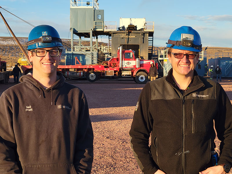 Two men in hard hats on a drilling site