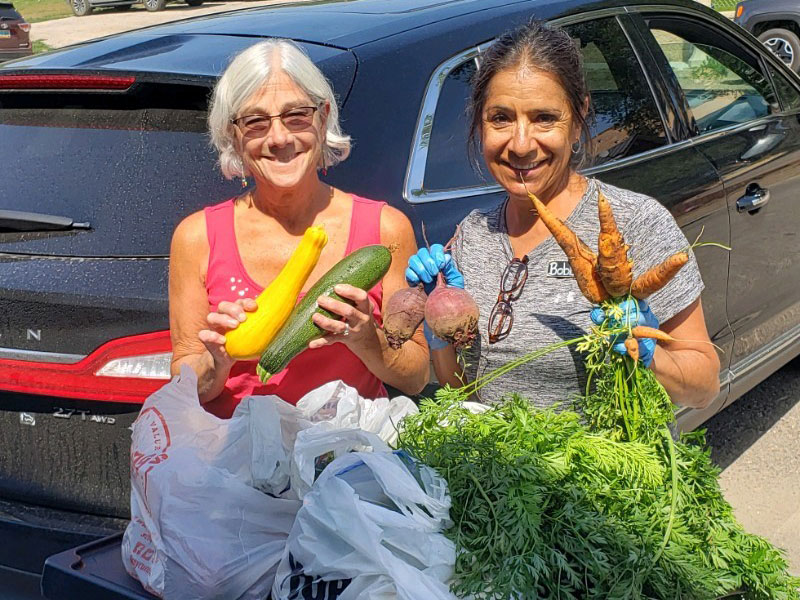 two women holding vegetables