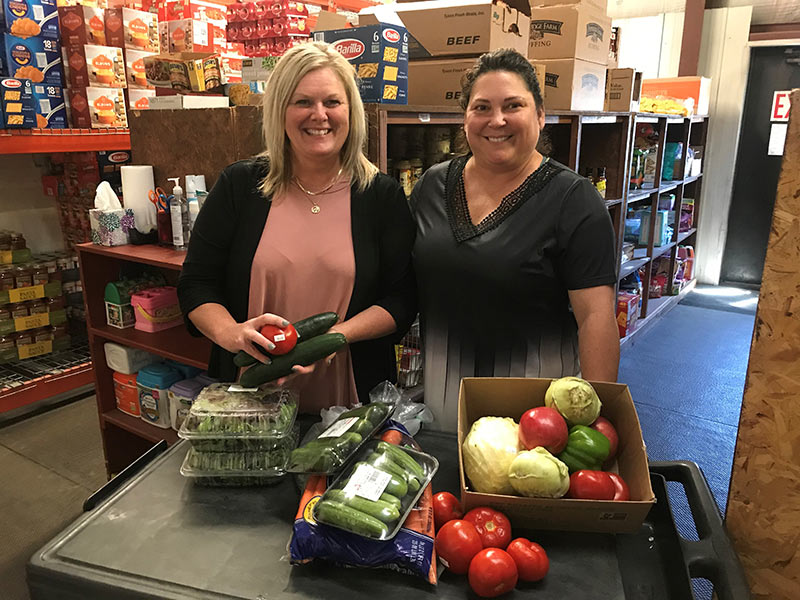 two women smiling with donated food