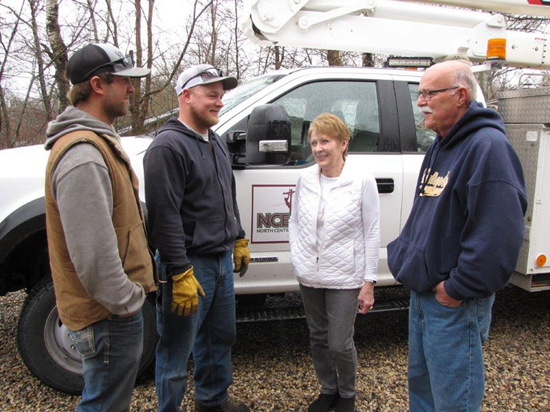 four people standing and talking