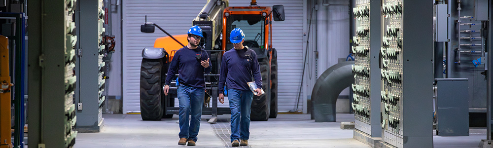 Two employees walking through a power plant