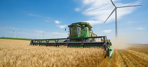 Combine with wind turbine in background