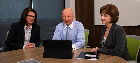 three people looking at laptop screen