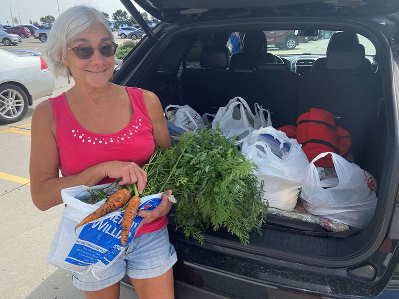 woman smiling holding carrots